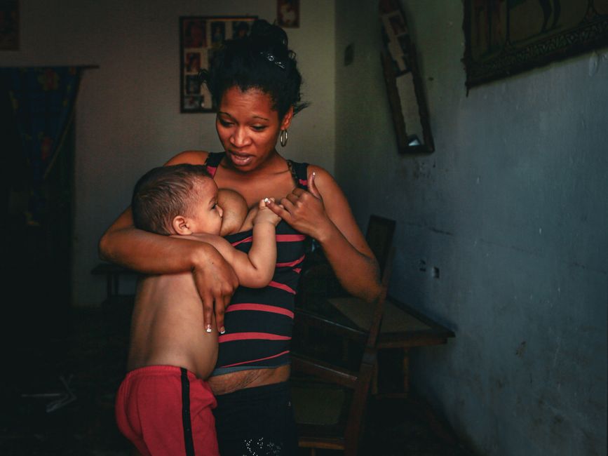 Mãe amamentando o bebê carinhosamente em casa