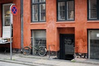 Black City Bike Parked Beside Orange Concrete Building