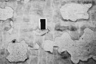 一堵老旧墙壁的特写，石膏纹理破裂，呈黑白两色