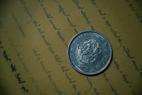 無料 茶色のプリンター用紙に丸い銀色のコイン 写真素材