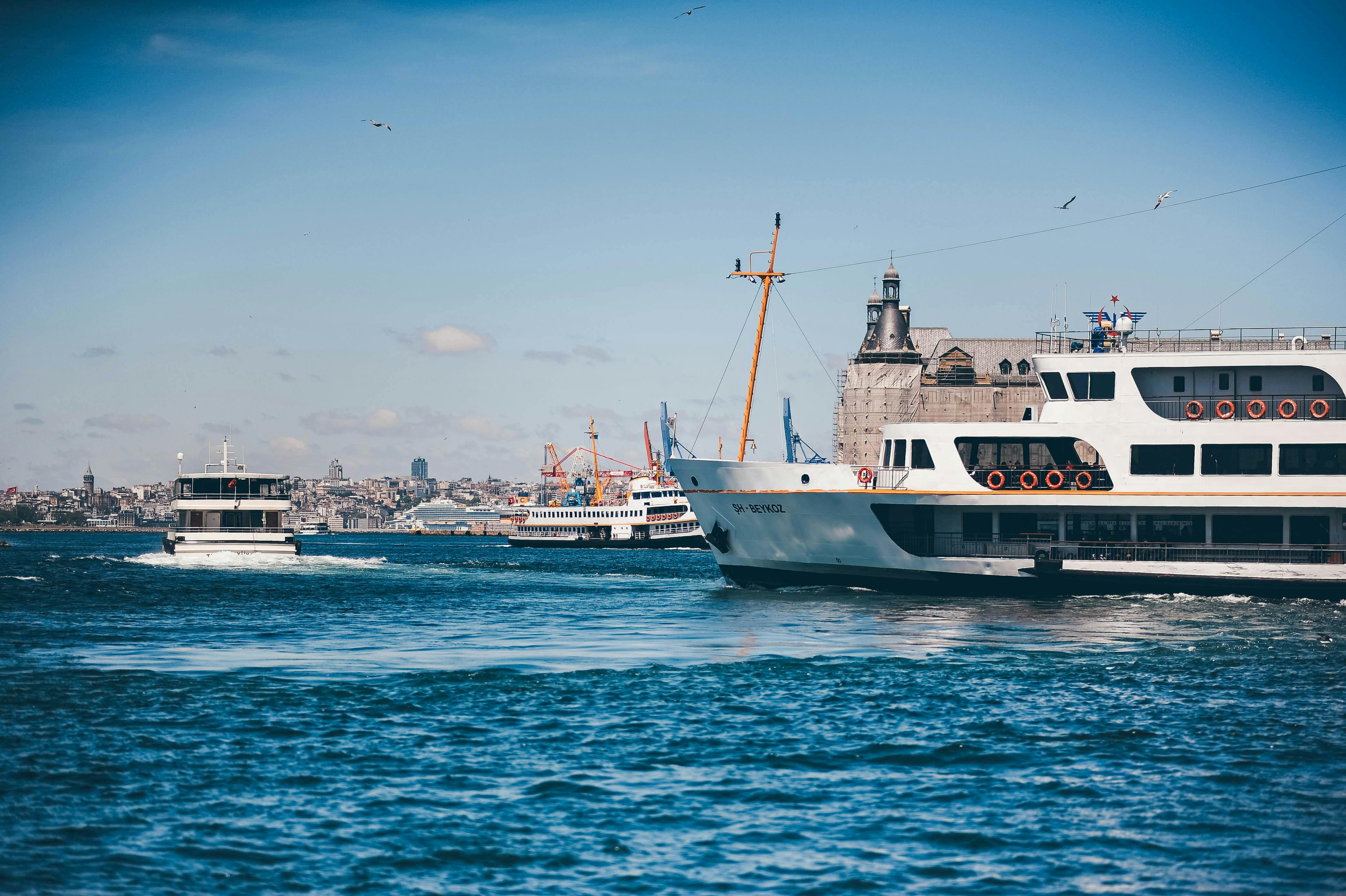 Free Ferries navigate the bustling waters of Istanbul with a historic backdrop under a clear blue sky. Stock Photo
