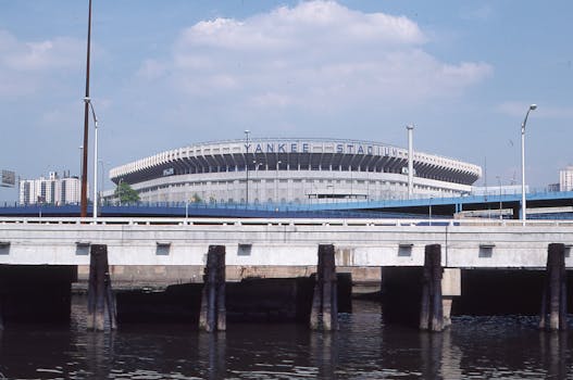 A scenic view of Yankee Stadium visible from a nearby waterfront bridge in New York.