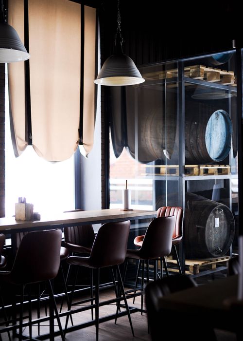 Free A modern industrial-style bar interior with barrels, high chairs, and large windows. Stock Photo