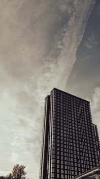 Low angle view of a modern skyscraper against a cloudy sky in Moscow, Russia.