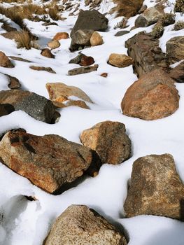 Close-up of snow-covered rocks on a winter day, showcasing natural textures.