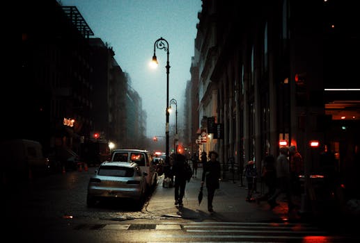 A vibrant street scene in New York City featuring pedestrians and cars at dusk.