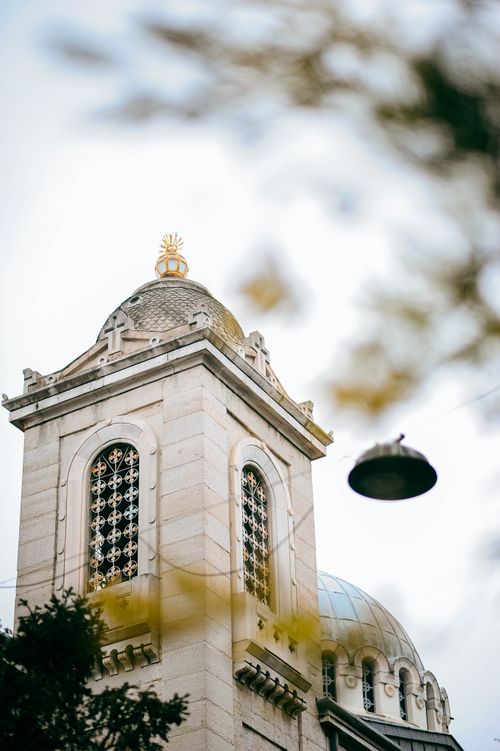 Free Low-angle view of an ornate church tower with decorative elements, showcasing urban religious architecture. Stock Photo