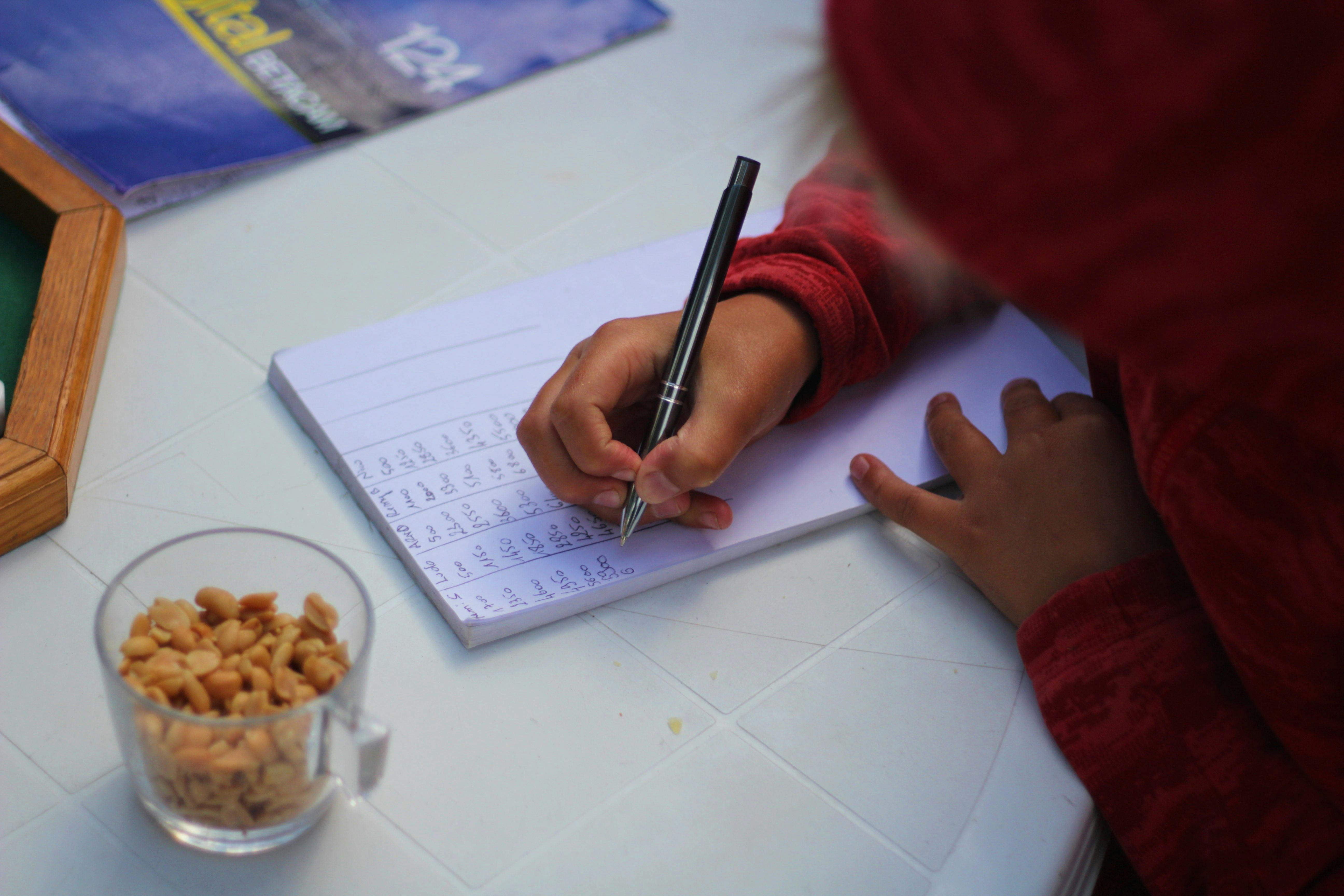 Person Writing on the Paper · Free Stock Photo
