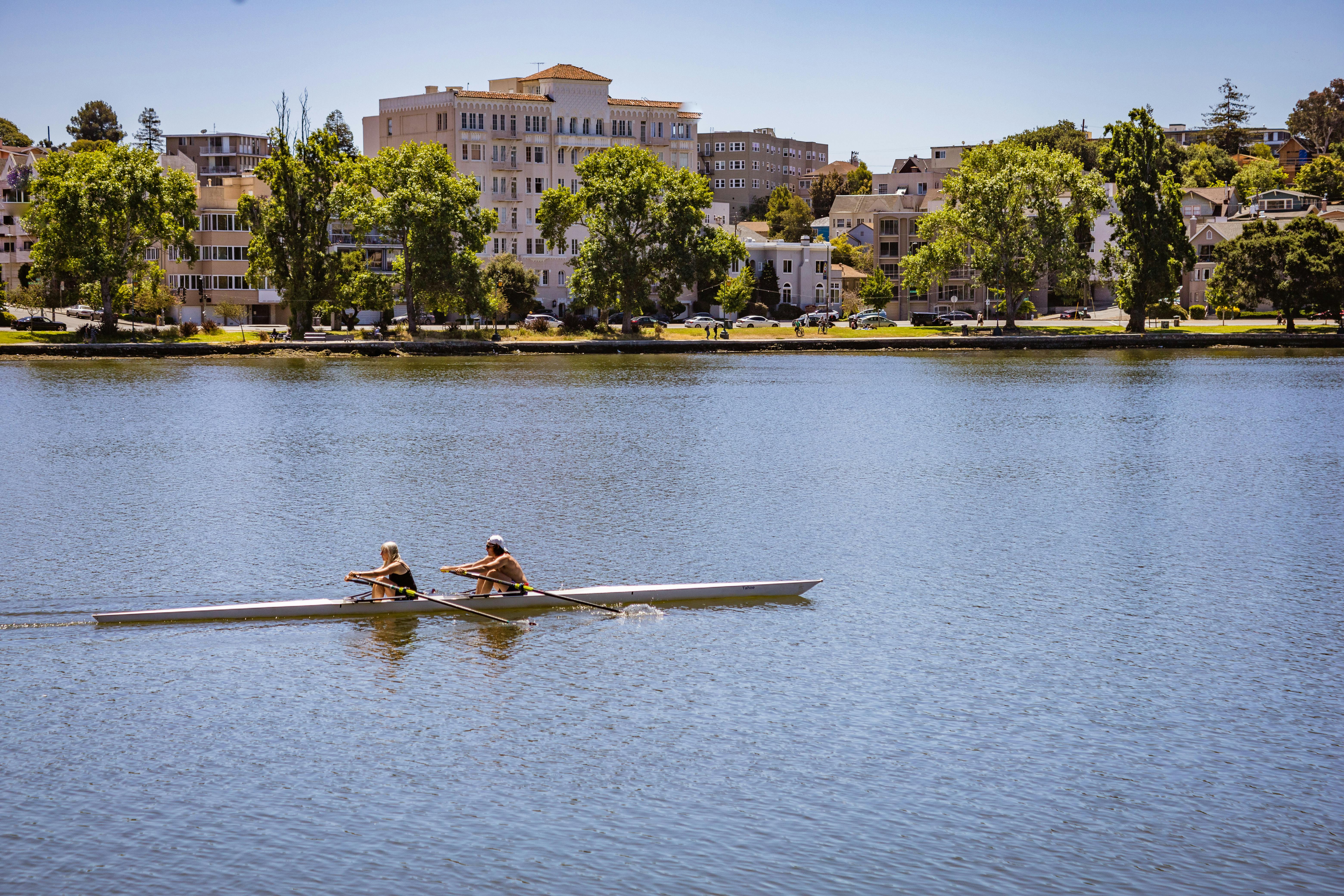 A couple sitting on a brick wall overlooking a scenic urban river landscape