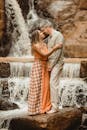 Shot of a Couple Embracing by a Waterfall