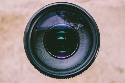 Detailed view of a camera lens capturing light and reflections, showcasing optical technology.