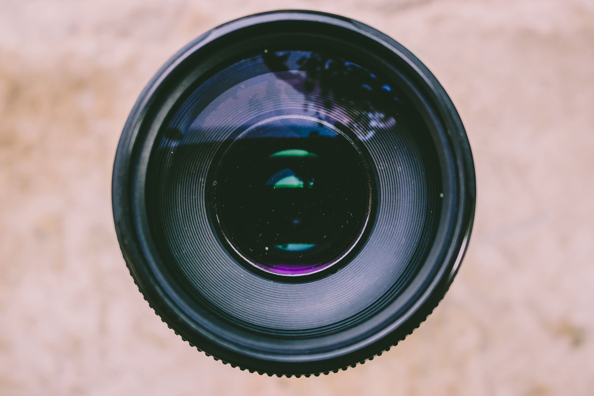Detailed view of a camera lens capturing light and reflections, showcasing optical technology.