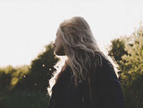 Free Silhouette of a blonde woman embracing the serene outdoors in Stirling, Scotland. Stock Photo