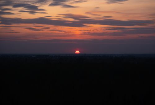 Free A beautiful sunset casting warm hues over the horizon, featuring a dramatic sky with scattered clouds. Stock Photo