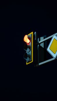 Traffic light showing a red stop signal at night against a dark sky.