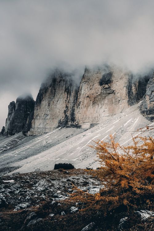 Free Cloud-covered mountains with vibrant autumn foliage in a scenic winter setting. Stock Photo