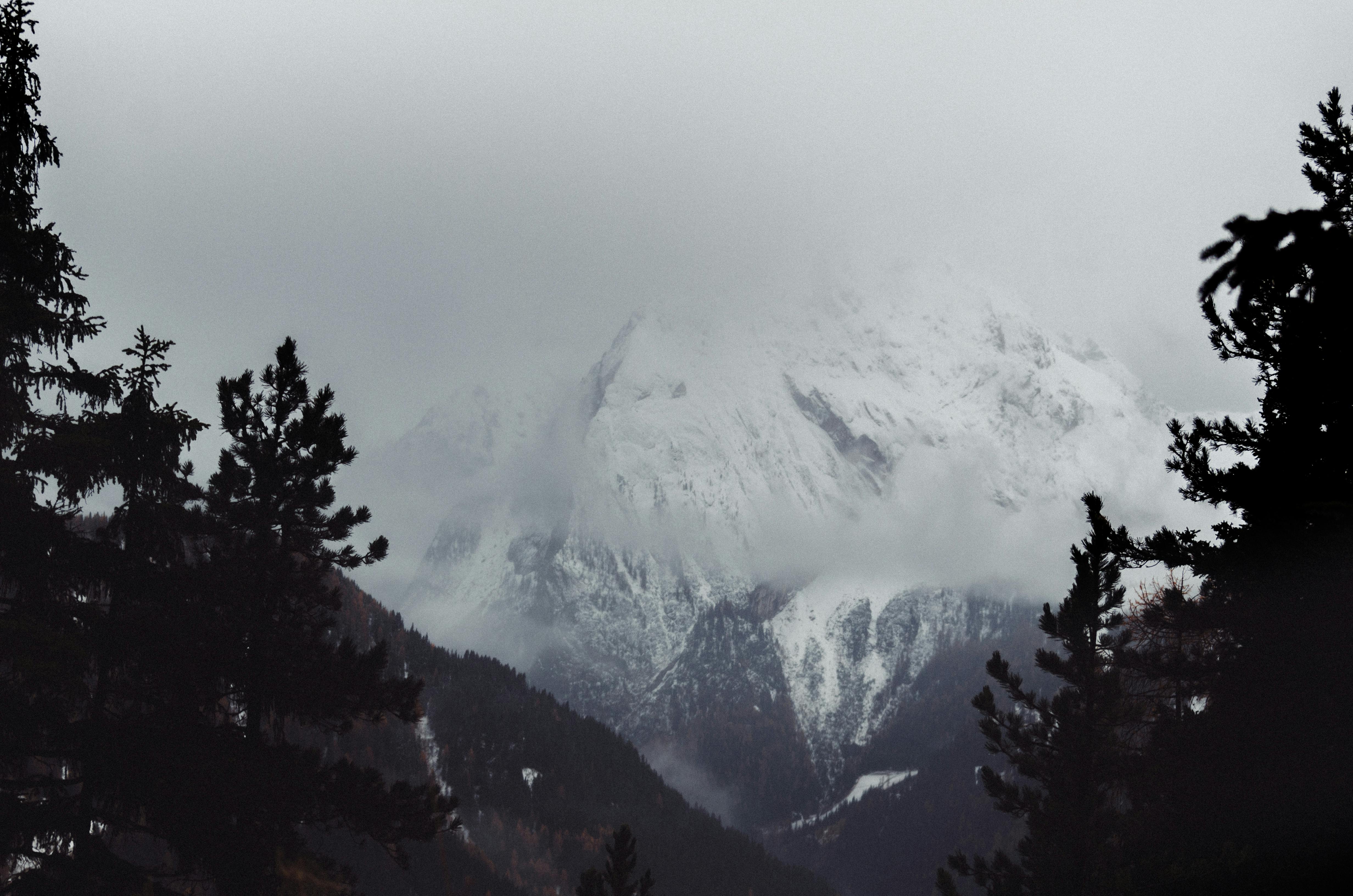 Prescription Goggle Inserts - Gloomy and mysterious view of snow-covered mountains in the Alps, surrounded by fog in winter.