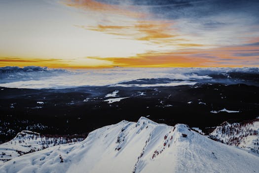 A stunning view of a snow-covered mountain with a vibrant sunrise. Perfect for winter themes.