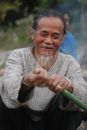 Man in Gray Sweater Holding Green Stick