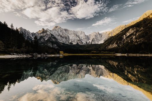 Stunning mountain lake reflecting rocky peaks and sky, creating a serene and picturesque landscape.