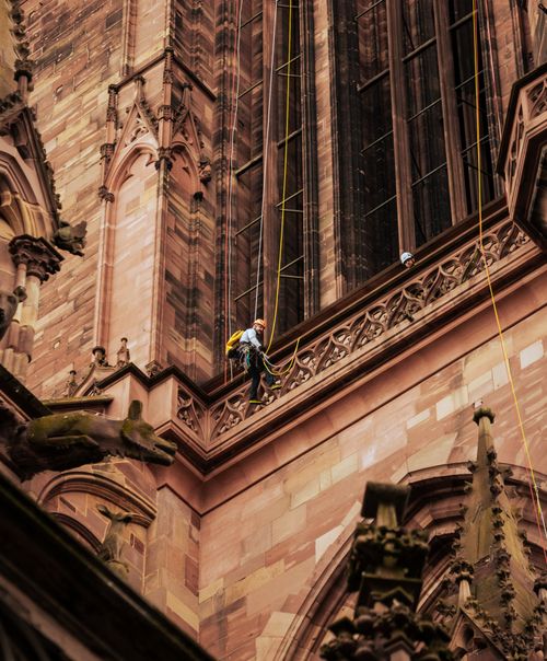 Free A climber ascends the historic facade of Strasbourg Cathedral in France. Stock Photo