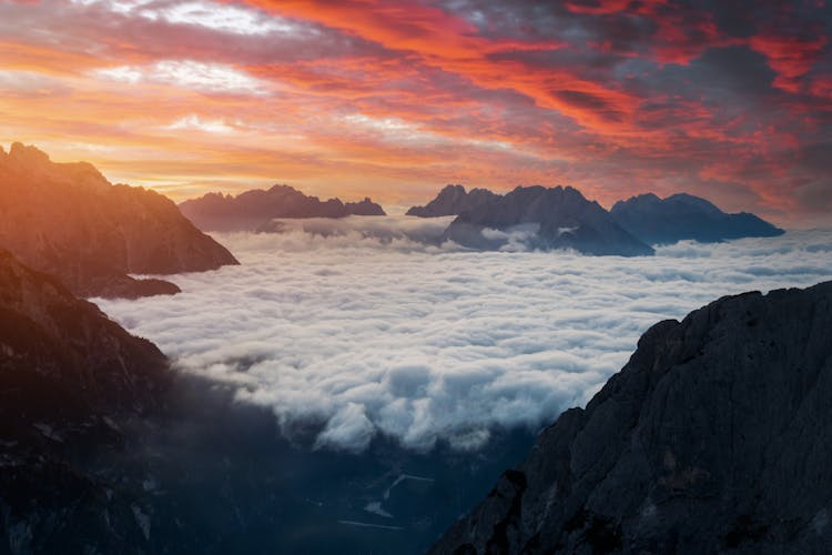 Mountain Peaks In Clouds And Dramatic Pink Sky