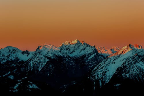 Snow Covered Mountain Under Orange Sky