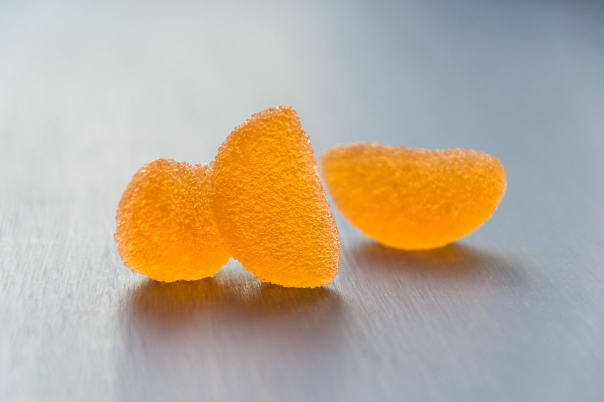 Bright macro shot showcasing textured orange jelly candies on a sleek surface.