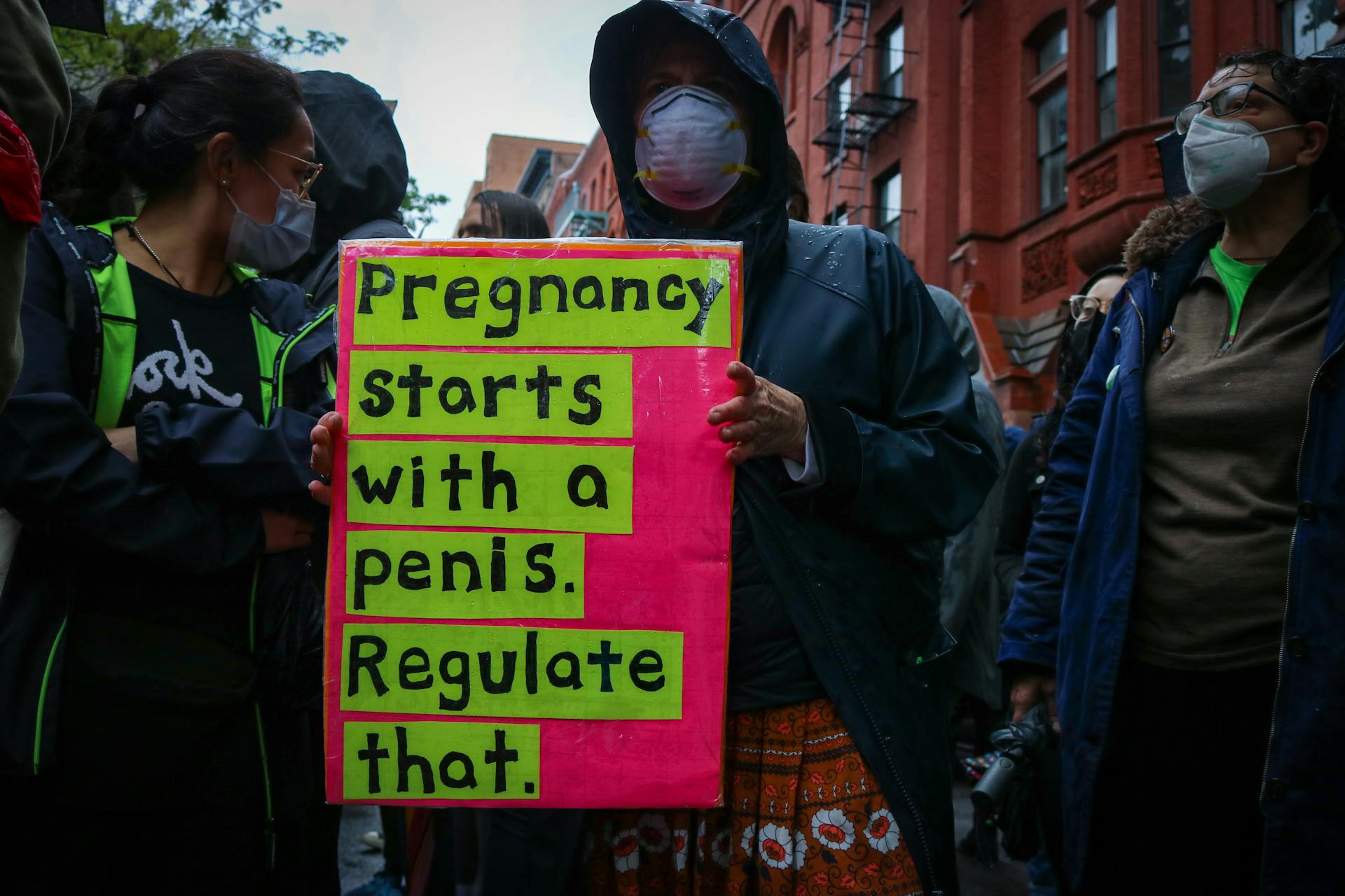 Protesters in New York City advocating for reproductive rights, holding bold placards.