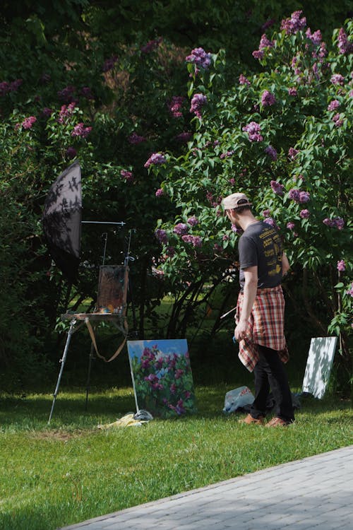 Man in Black T-shirt Standing on Green Grass Field