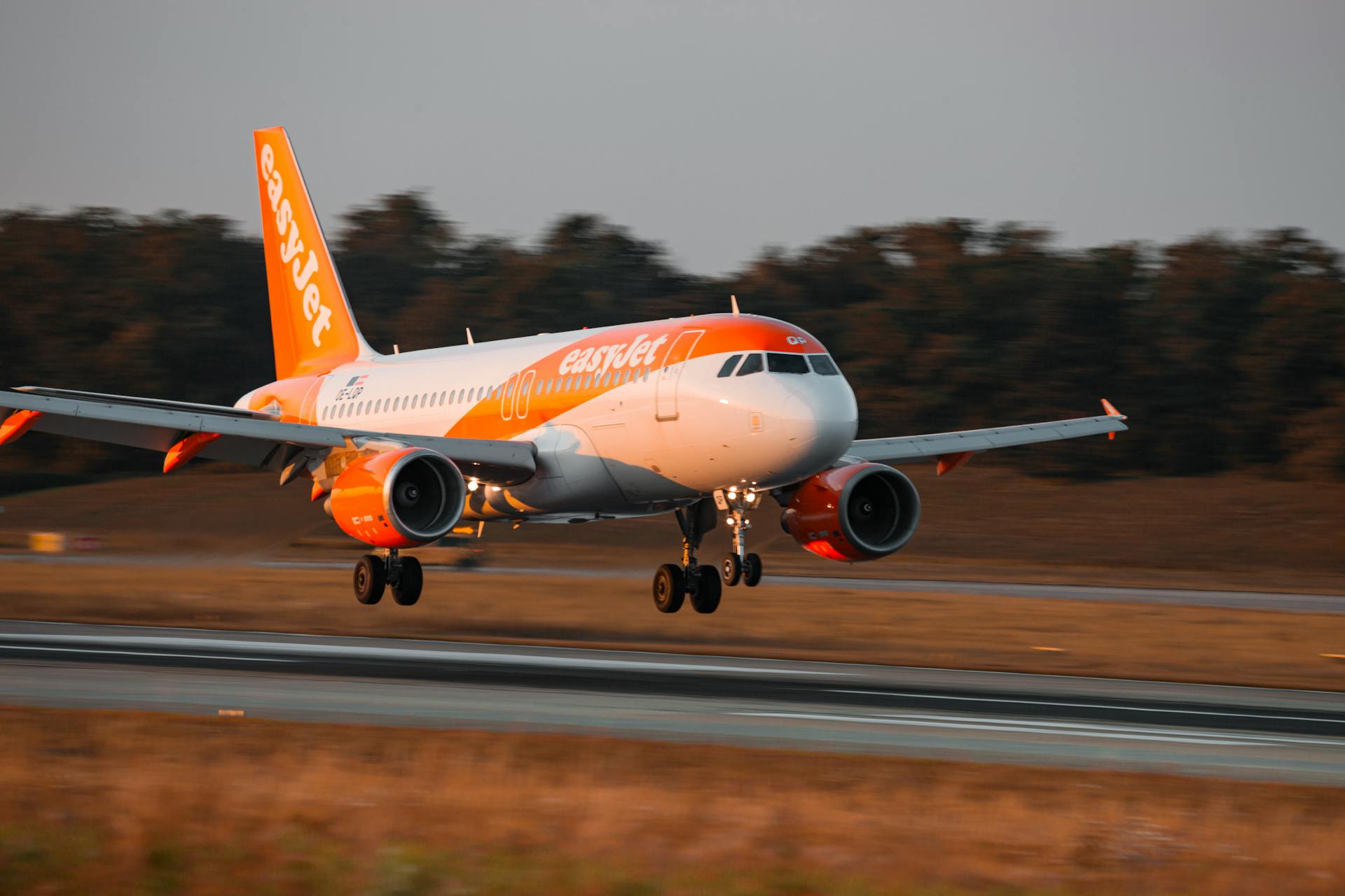 A vibrant airplane landing on a runway during sunset, symbolizing travel and transportation.