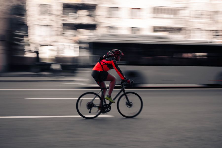 A courier cycling through a city street — Maksim Krapivin on Pexels