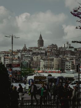 Crowded urban street in Istanbul with a view of the historic Galata Tower.