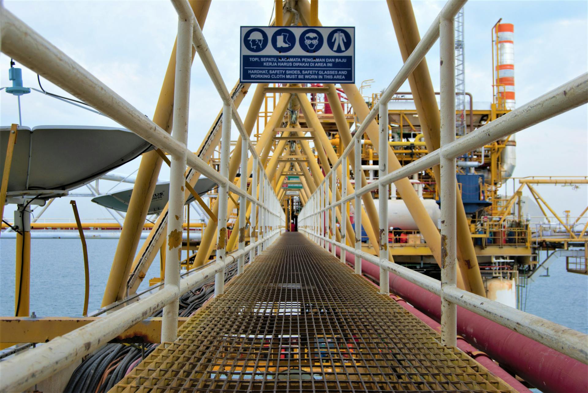 A steel walkway leading to an offshore oil platform in Indonesia, showcasing industrial architecture.