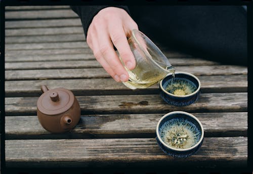 Pouring Green Tea Into Porcelain Bowls