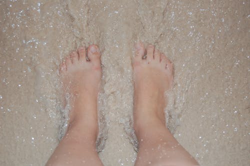 Gratis Fotos de stock gratuitas de agua, arena de playa, con los pies descalzos Foto de stock