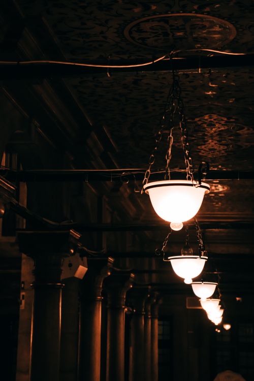 Free Warmly illuminated hanging lamps inside a historical building in Istanbul, evoking a classic atmosphere. Stock Photo