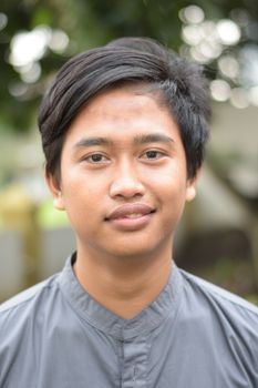 Close-up portrait of a young man outdoors with a soft blurred background. - Fotografer Sidoarjo