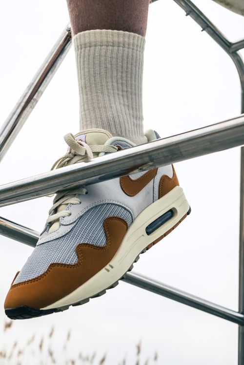 Free Close-up of Nike Air sneakers resting on a metallic framework, showcasing style and detail. Stock Photo