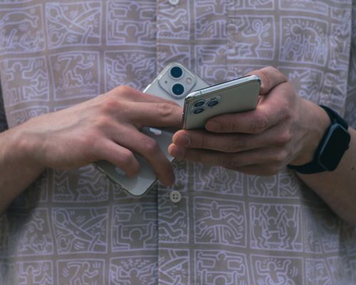 Free Detail of hands holding two smartphones, showcasing modern technology usage. Stock Photo