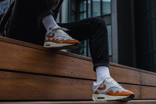 Free Casual street style with fashionable sneakers perched on a wooden bench outdoors. Stock Photo