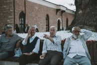 3 Men and 2 Women Sitting on Brown Concrete Bench