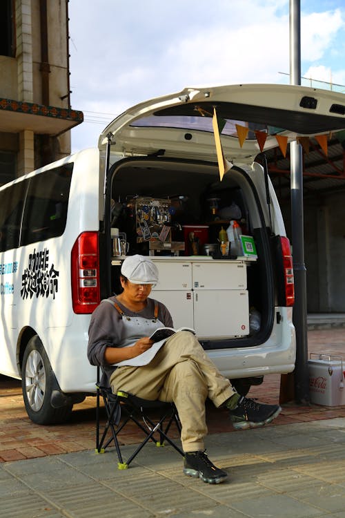 A Man Sitting Beside the White Van