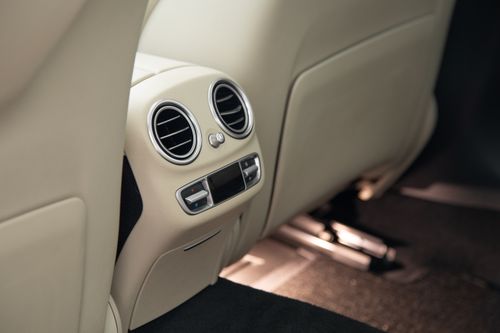 Free Close-up view of a luxury car's rear air conditioning vents and beige leather interior. Stock Photo