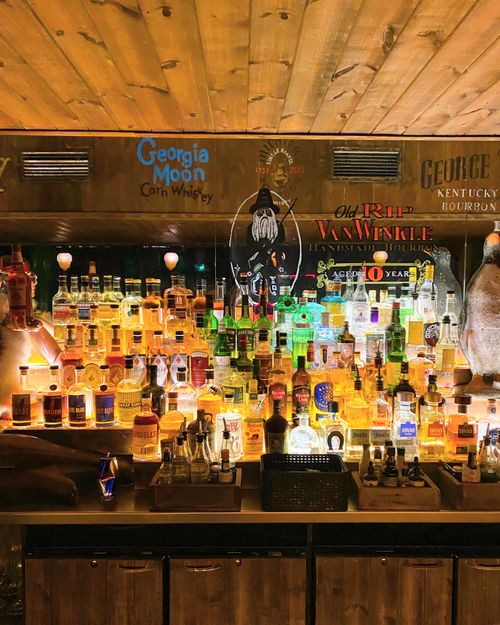 Free Vibrant assortment of liquor bottles beautifully displayed in a London bar setting. Stock Photo