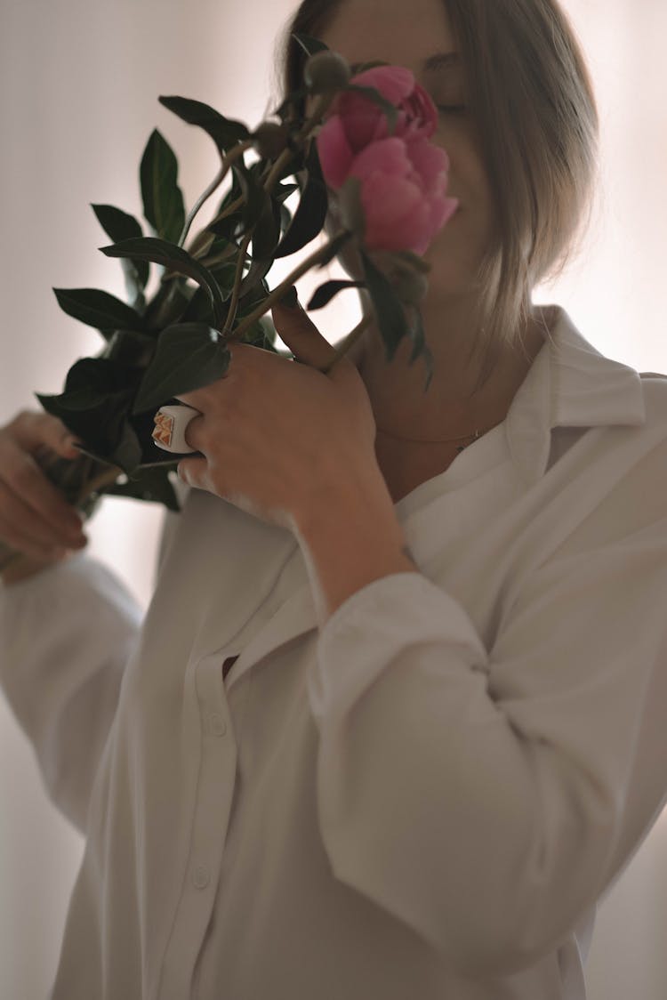 Beautiful Woman In White Dress Shirt Smelling A Flower 