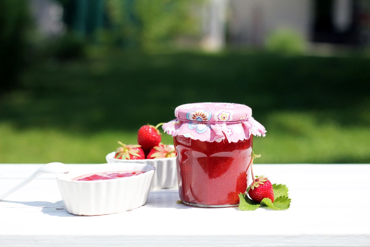 fresh homemade strawberry jam in a decorative jar with ceramic bowls o