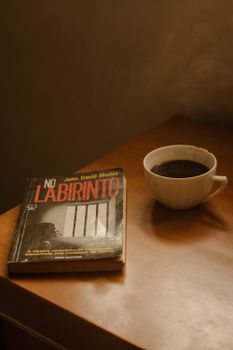 A warm, inviting scene featuring a cup of coffee and a book on a wooden table.