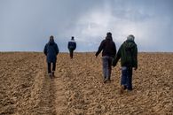 Group of People Walking on Brown Field