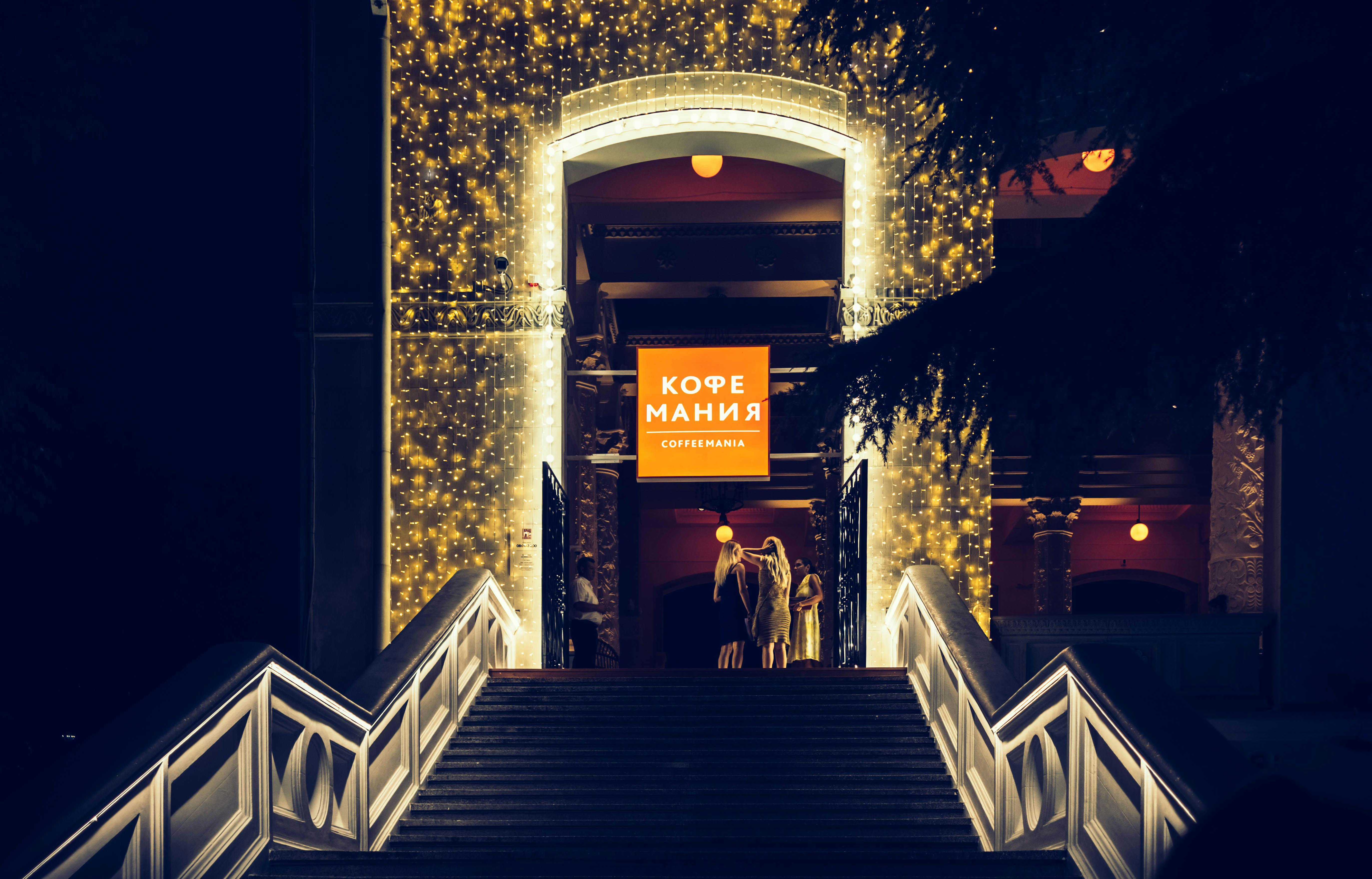 夜晚，俄罗斯索契一家灯光精美的咖啡馆入口，充满了节日的灯光和人群